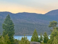 View from the upstairs bedroom balcony at Whistling Moose Lodge—peaceful pines, shimmering Grand Lake, and snow-tipped peaks kissed by sunrise. A place where the quiet beauty soaks into your soul and melts away every bit of stress and pain