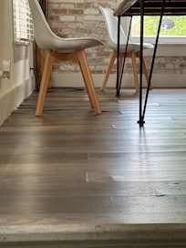 Flooring pulling up is bad under dining table.