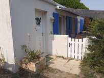 Eingang zum Ferienhaus und Terasse mit Morgensonne, durch Markise geschützt.