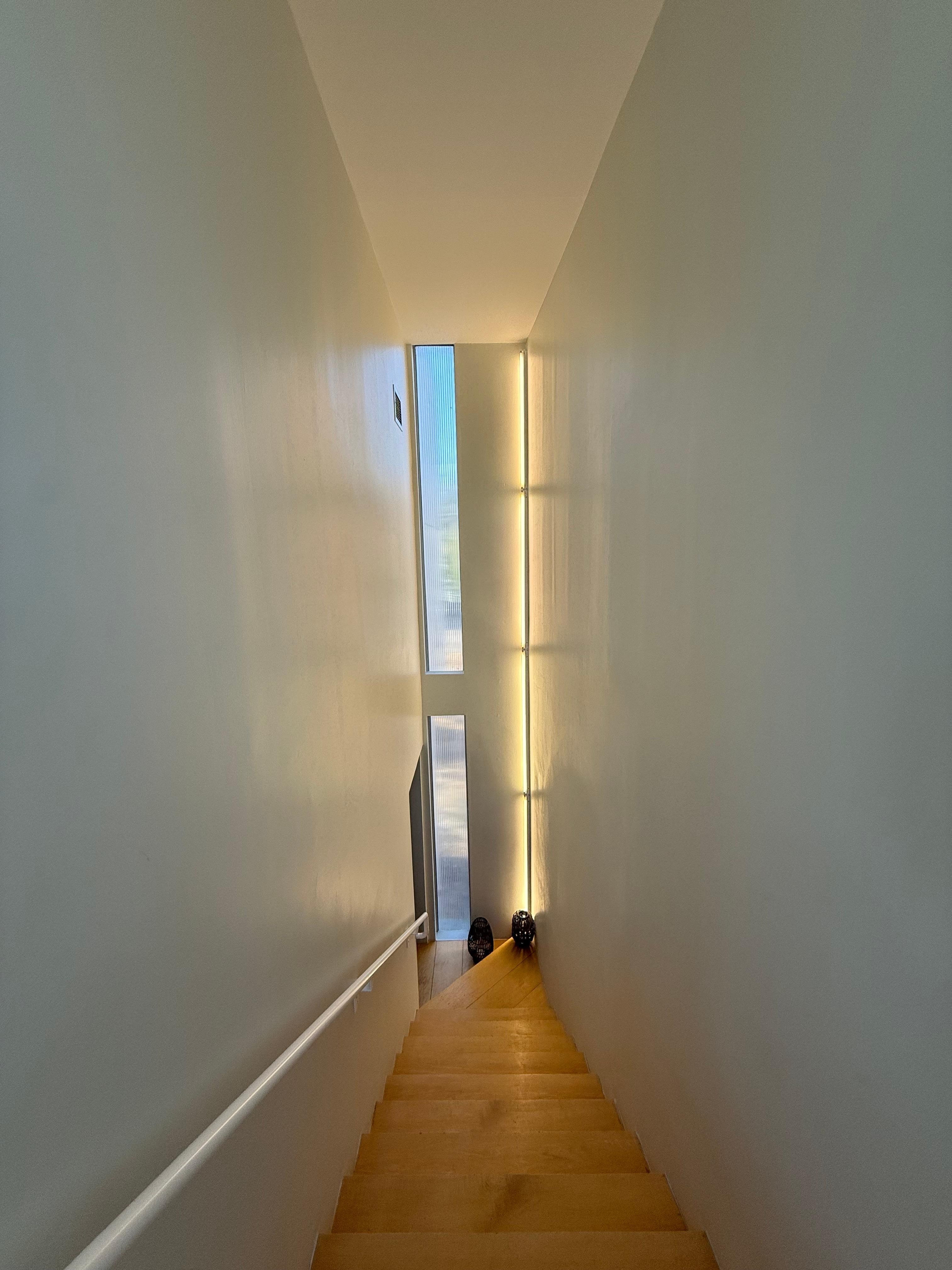 Cool looking staircase that separates the upstairs bedroom, bathroom, kitchen, dining, and living area to the downstairs entry/exit, 2nd bedroom, and bath