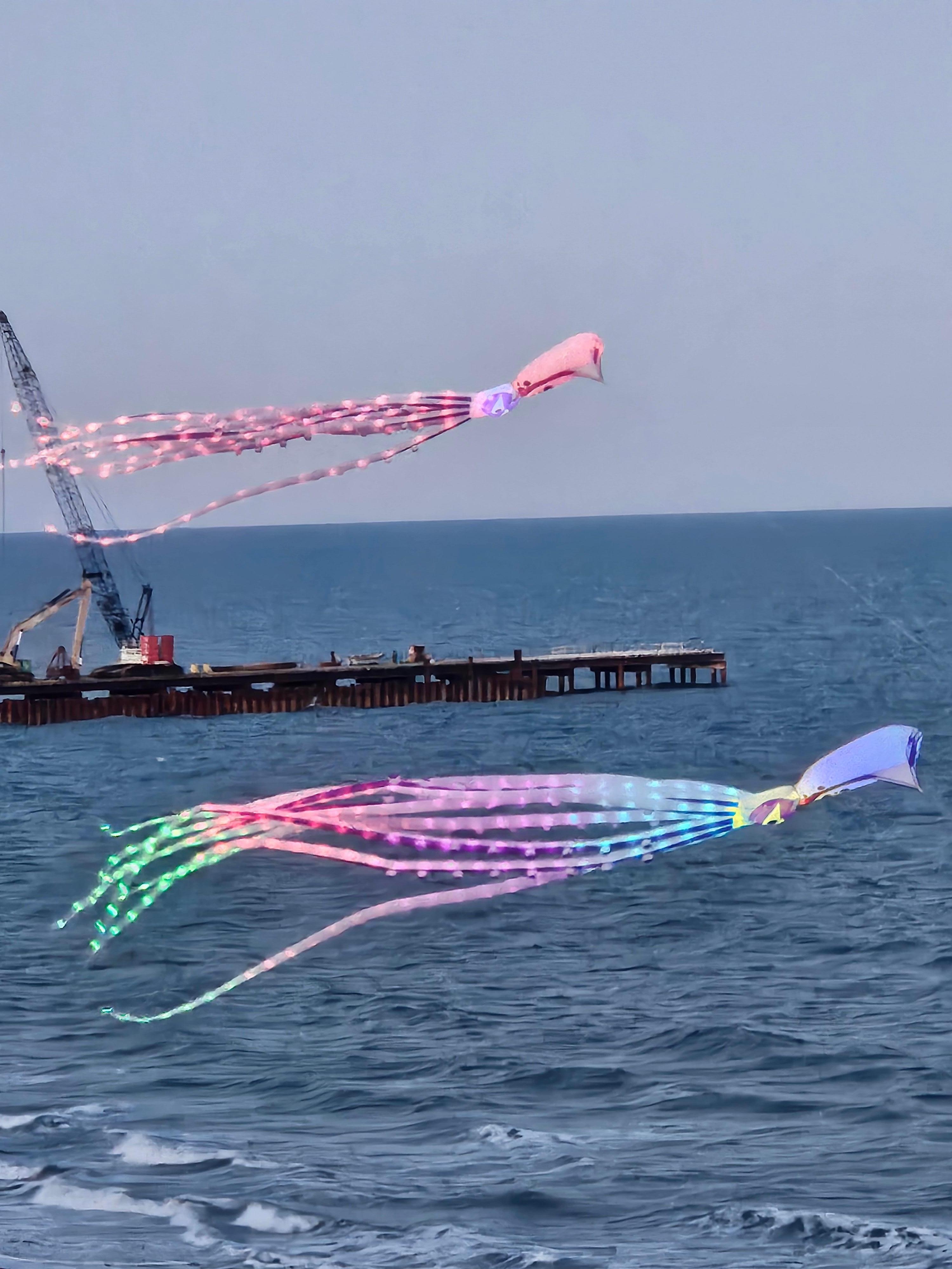 Man flying beautiful lighted kites right outside our balcony.