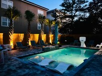 Beautifully lit backyard and pool at night to sit and enjoy your family and meals