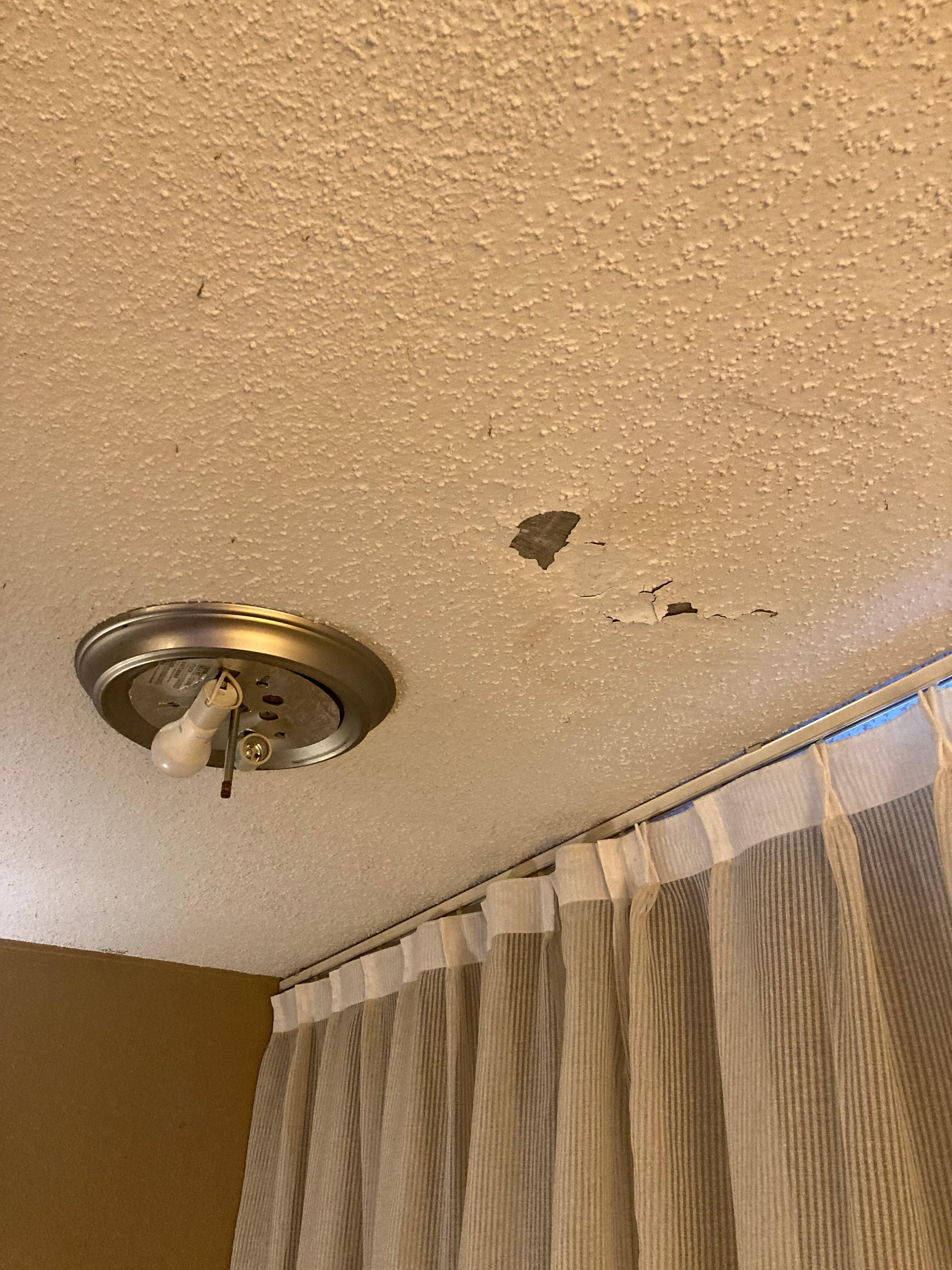 Here’s another exposed light close to the curtains but there was multiple holes and cracks in the ceiling.
