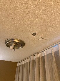 Here’s another exposed light close to the curtains but there was multiple holes and cracks in the ceiling.