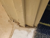 Dirt on the floor of the doorway to the bathroom.