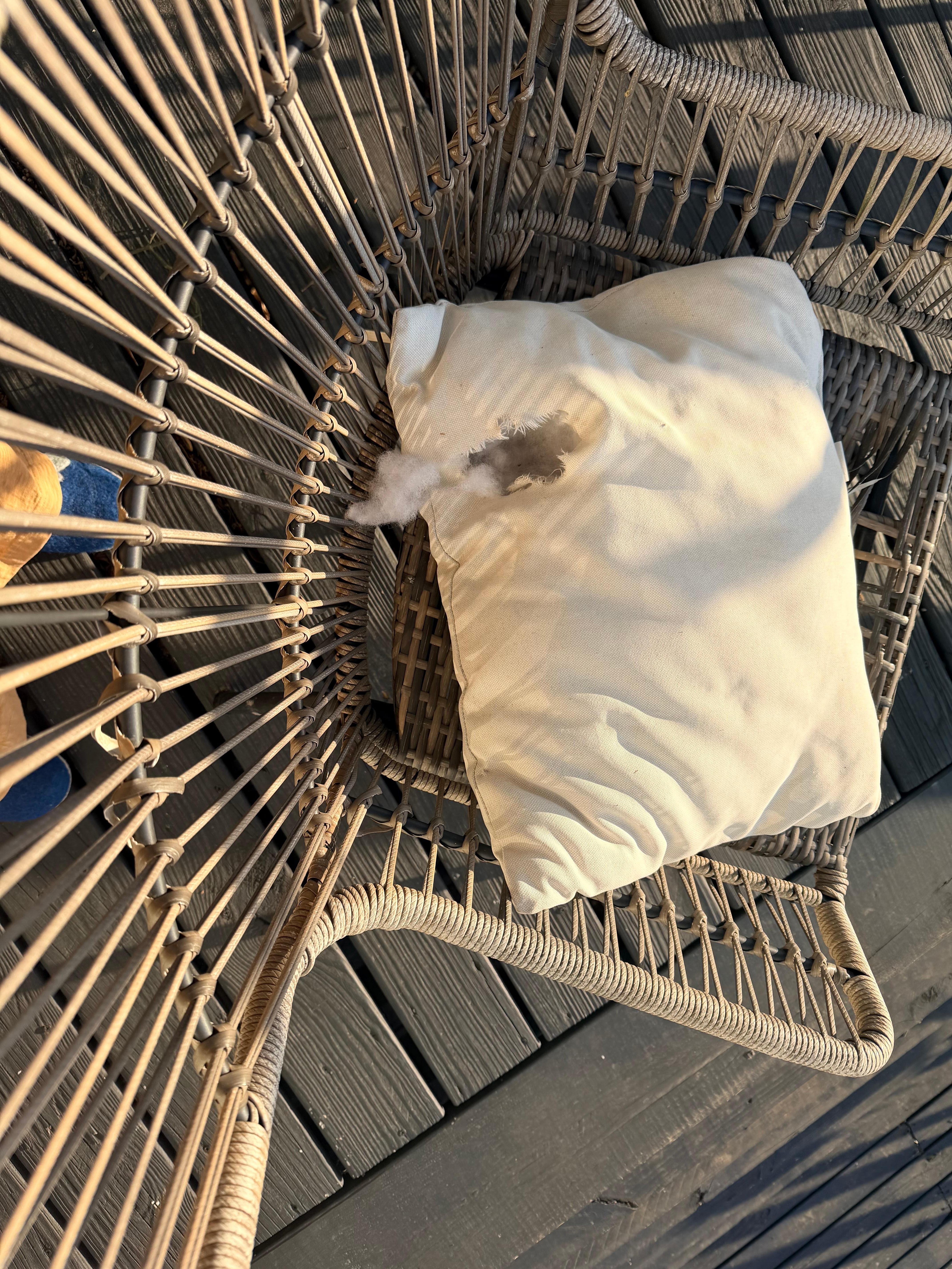 One of the two broken chairs on the upper deck with a holey pillow covering