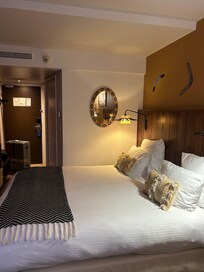 部屋の窓側から撮った写真です。左側には机とコーヒーマシンなどがあり、右側にはテーブルと1人用のソファのようなものがありました。