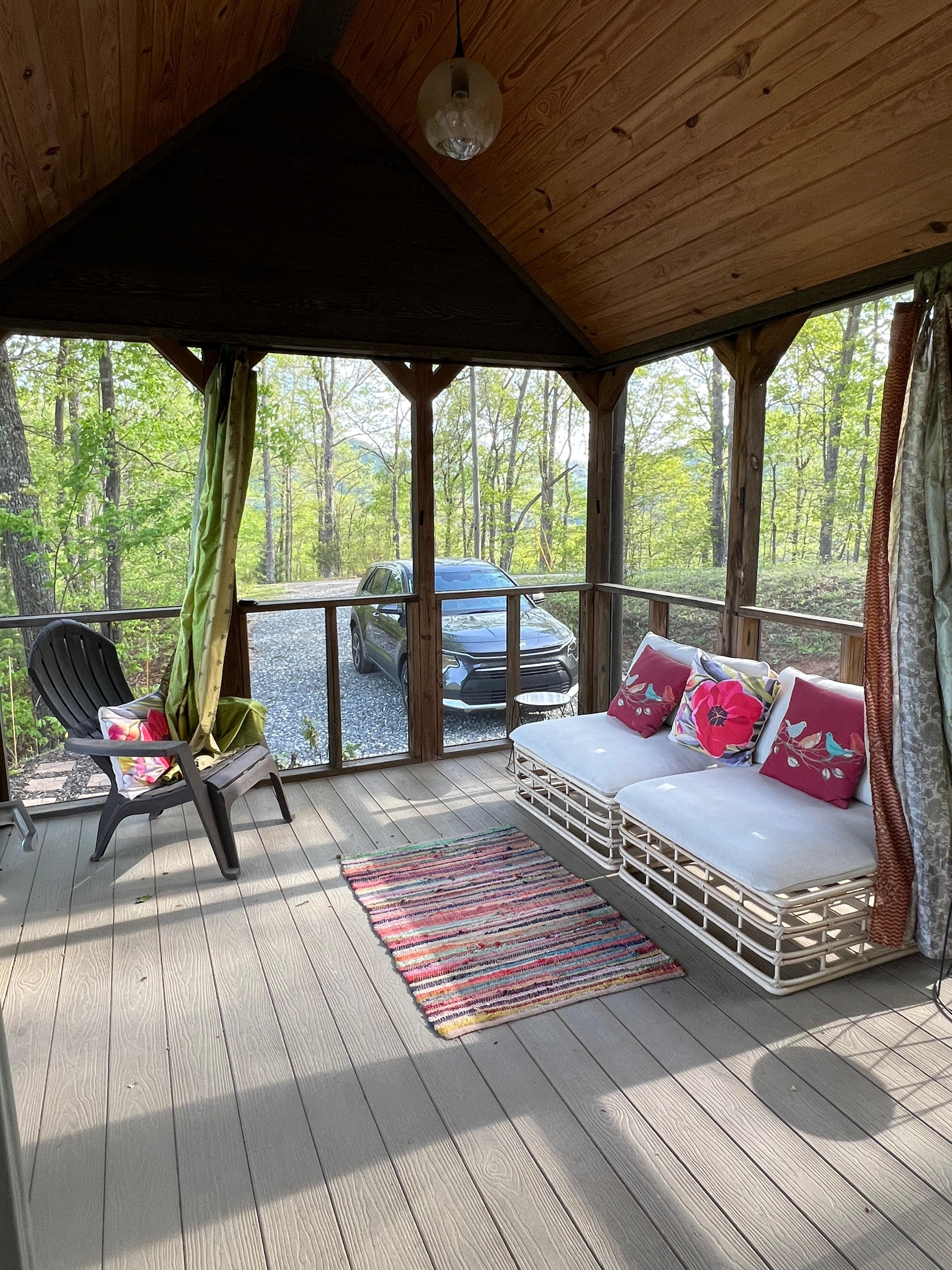 The screened in porch and driveway (the road passes right by the back of the cabin)