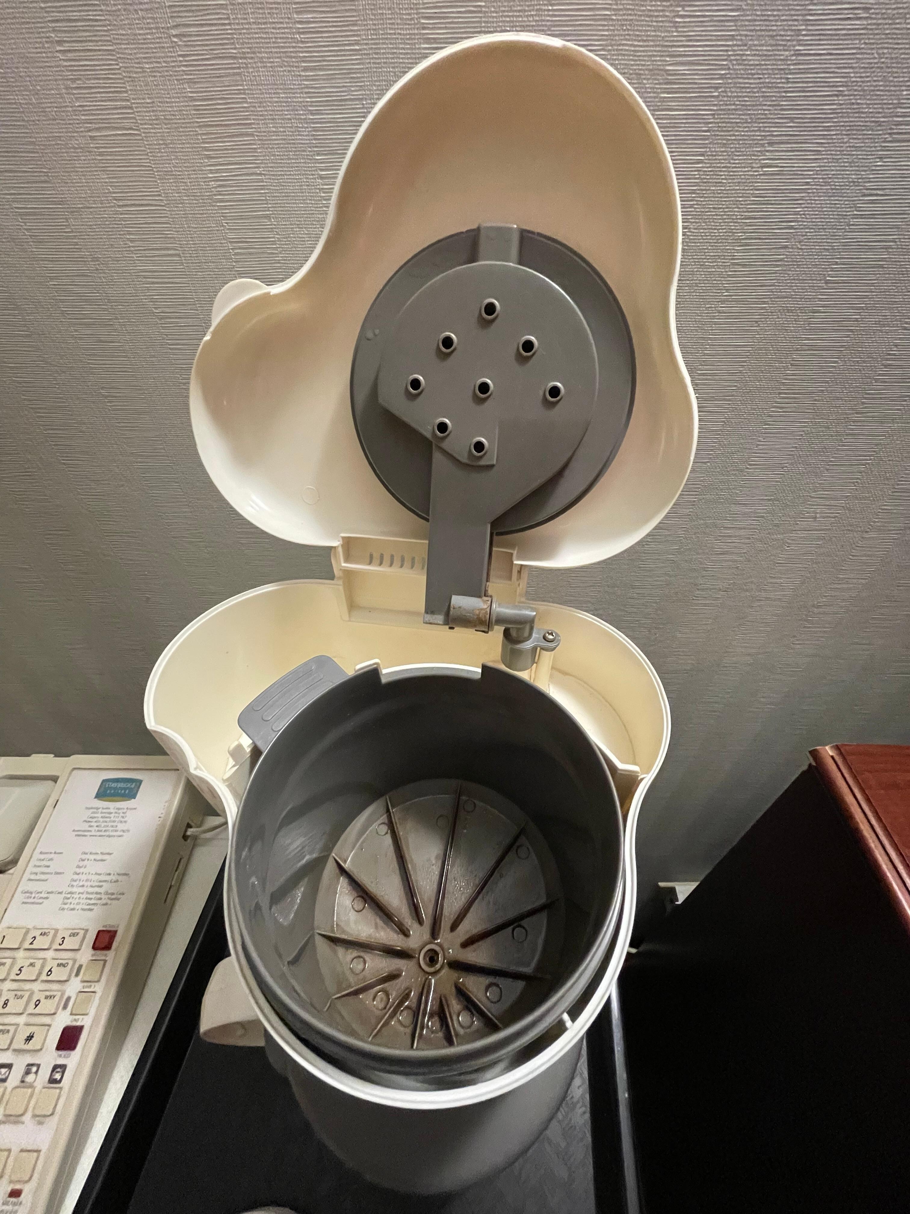 Unclean old coffee maker, with paper cups