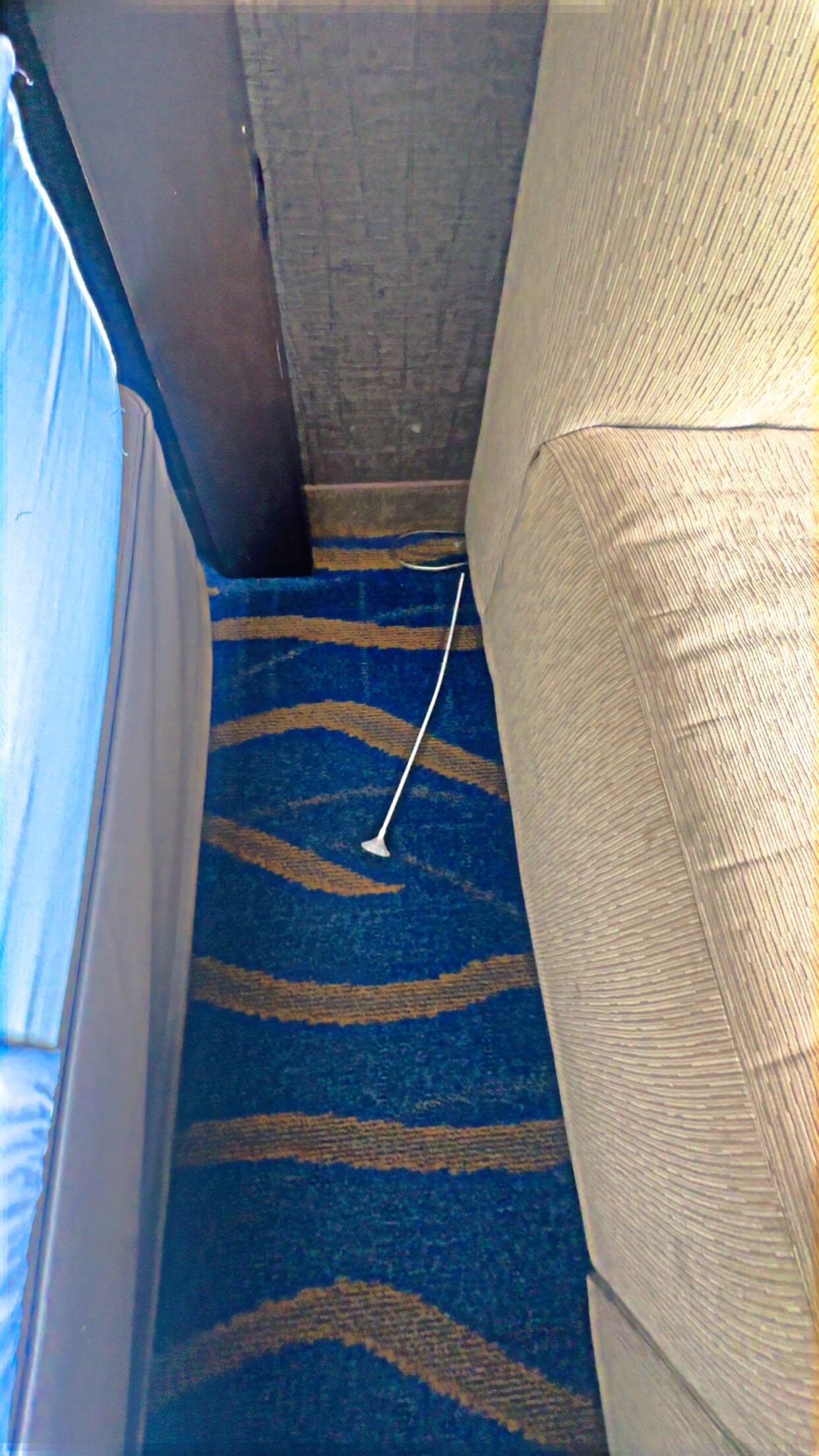 Stained couch some kind of object on the floor