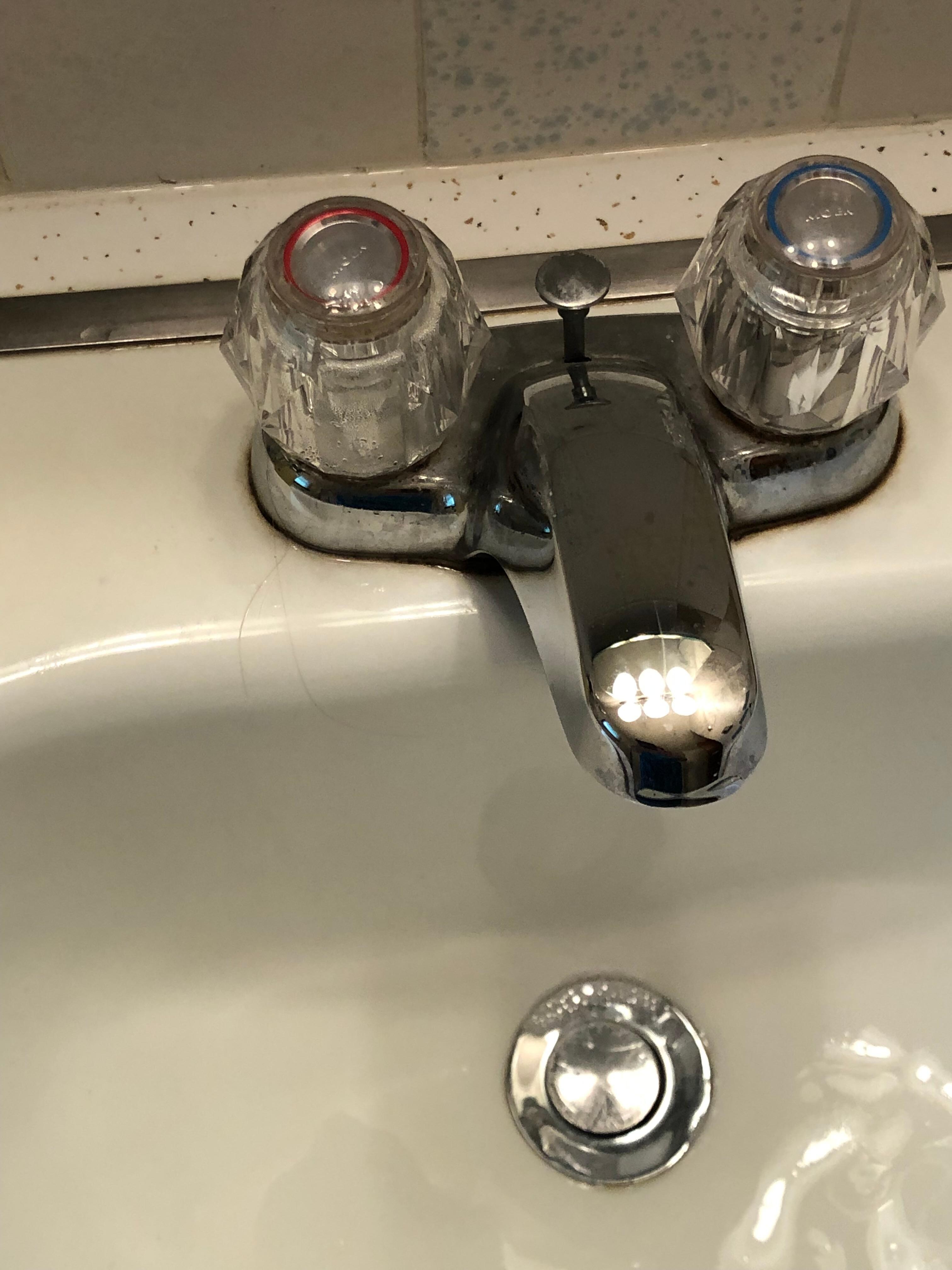 Sink also had debris around the faucet in bathroom.