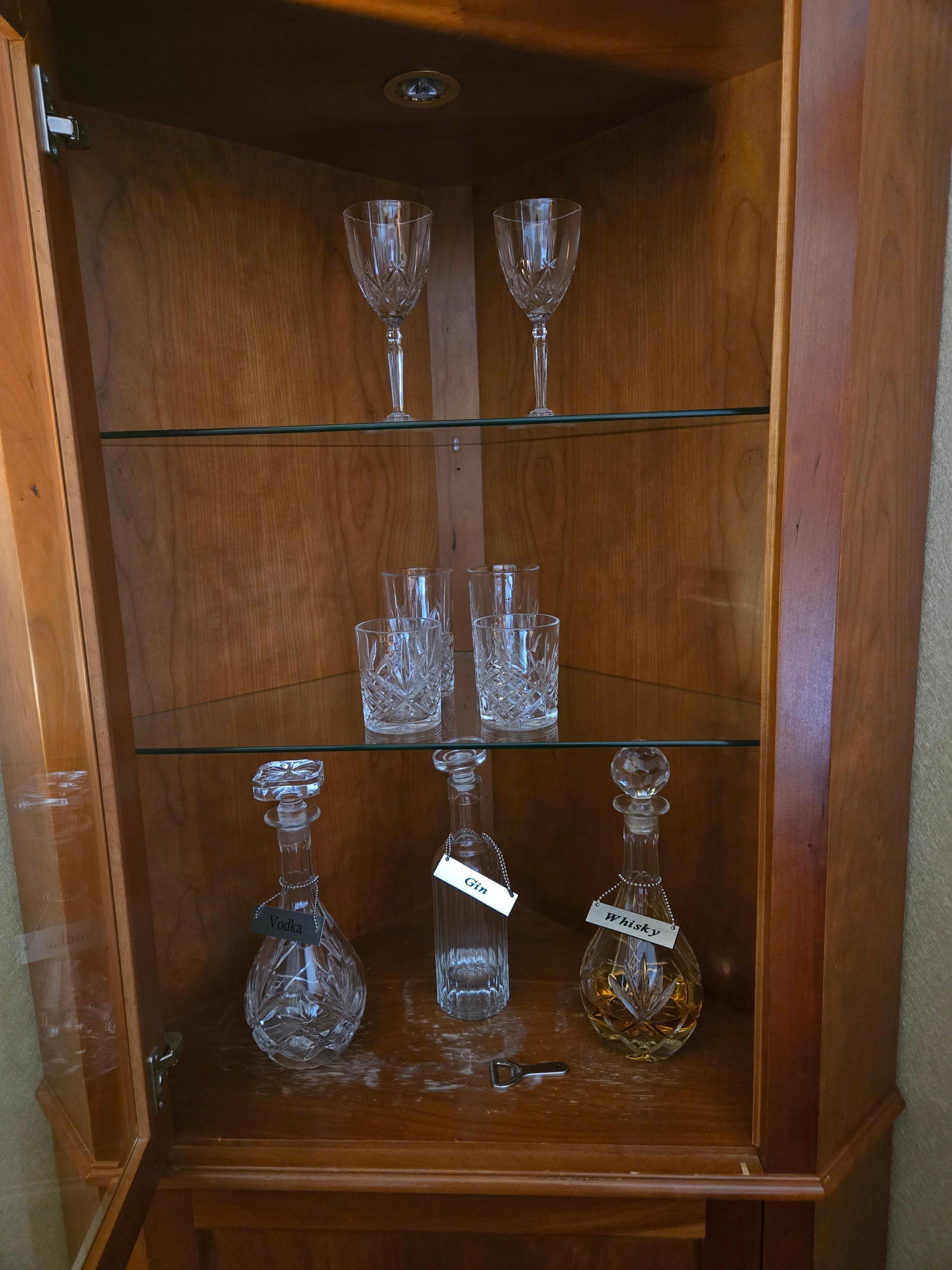 Corner cabinet with whiskey, vodka, gin, and quality glassware.