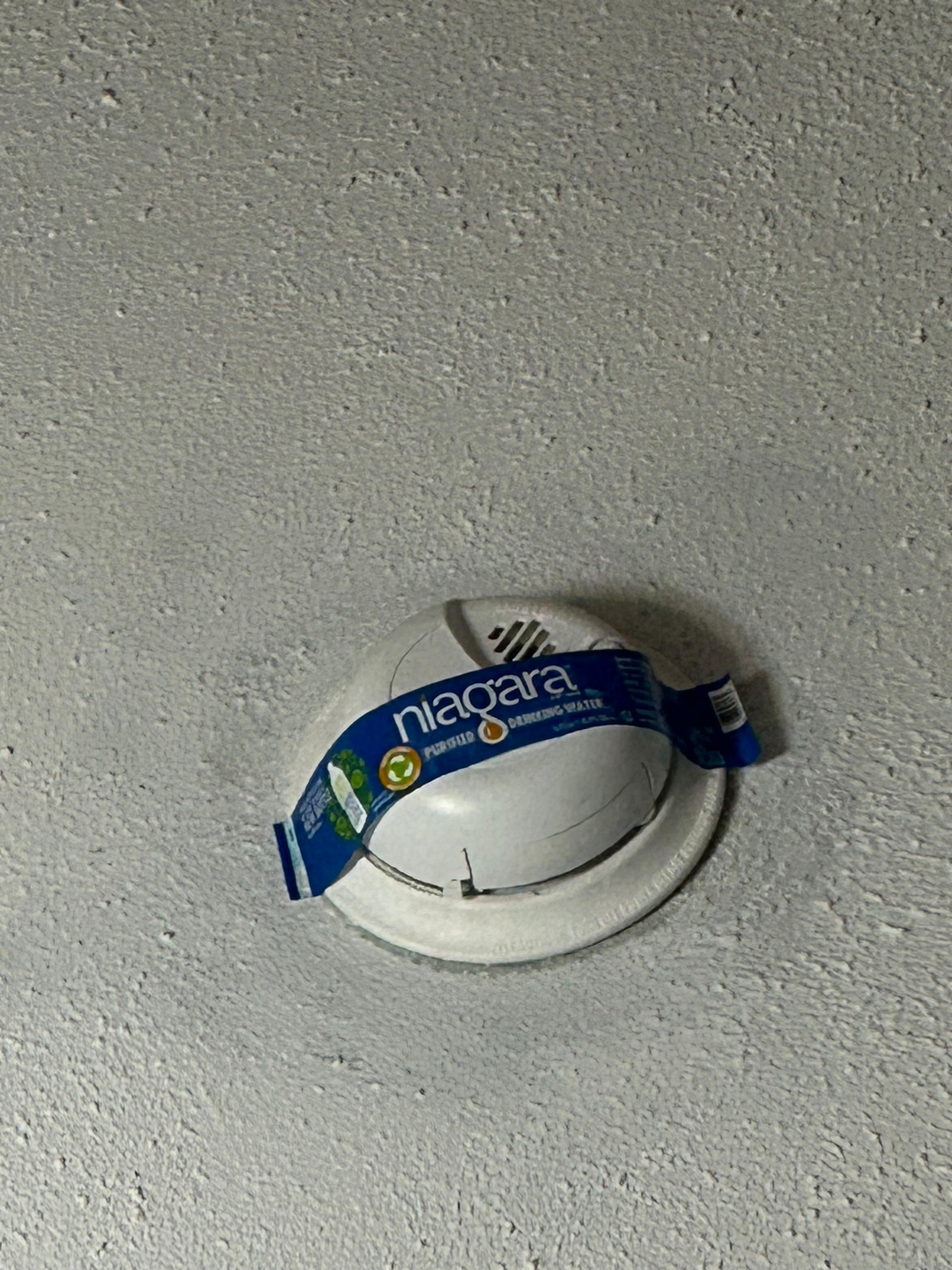 Who knows when it happened, but someone stuck the label from a Filterd Water bottle over the smoke detector. Most likely just to block the annoying red light that keeps blinking.