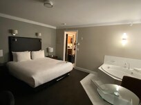 Bedroom area has king size bed, jacuzzi tub and desk area. This picture shows the doorway to the kitchenette entranceway.