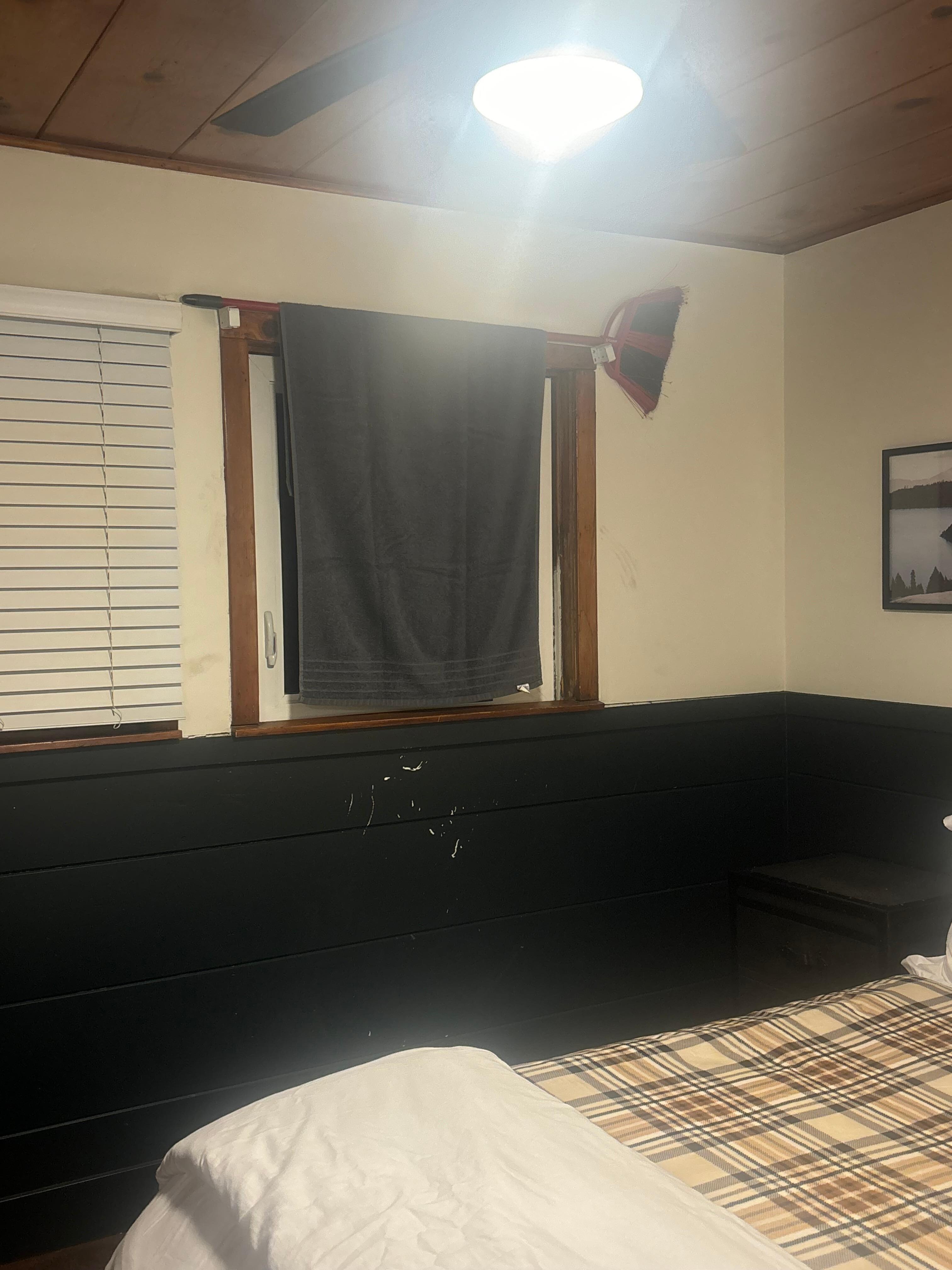 Broken window covered with towel held up by broom