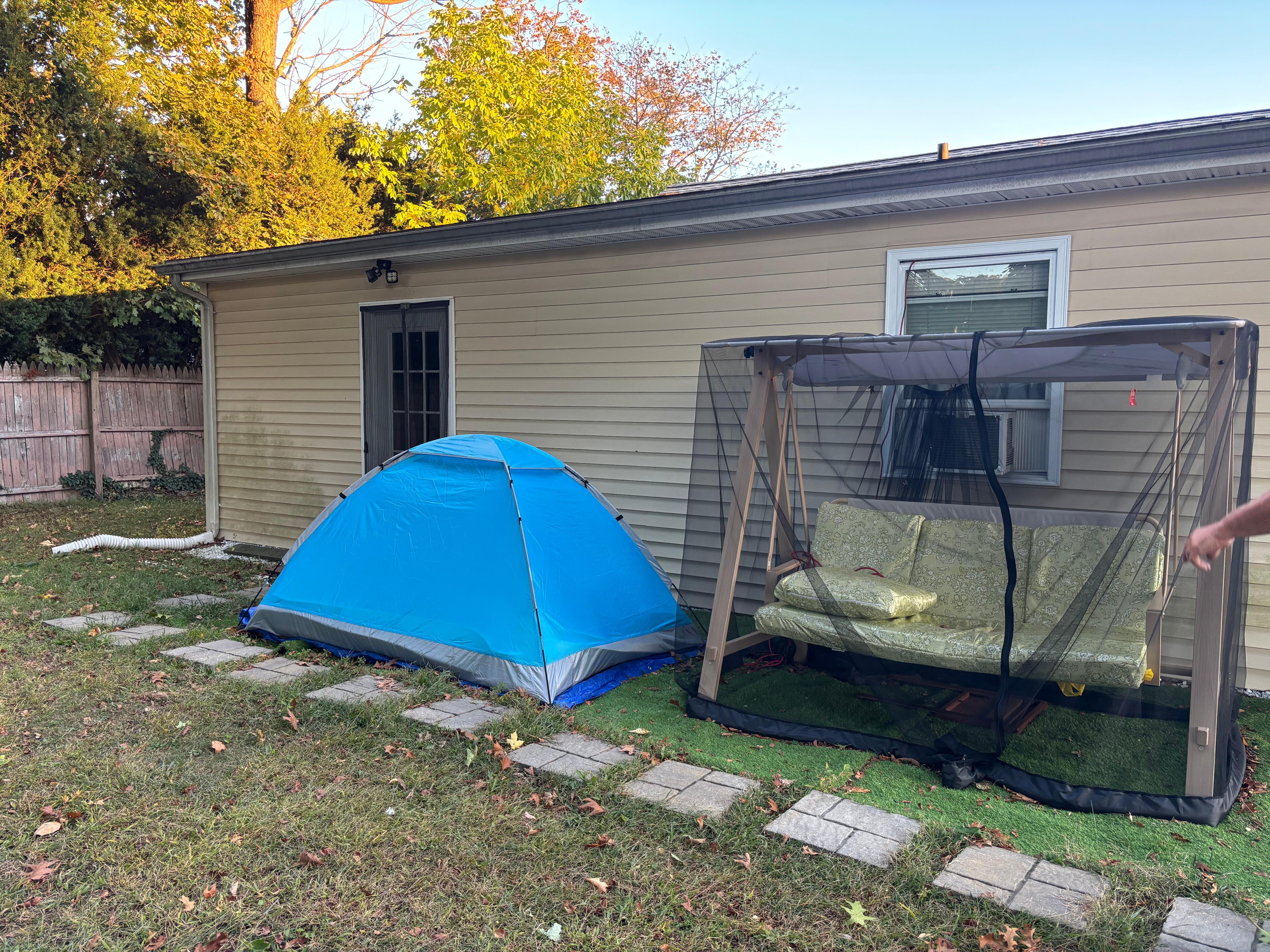 Tent someone was using and separate entrance next to tent for “long-term on-site separate unit rental” (aka back of house I was renting!