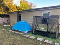 Tent someone was using and separate entrance next to tent for “long-term on-site separate unit rental” (aka back of house I was renting!