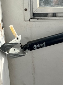 Screen door being held with a mini screw driver. The part is $12 like really?!