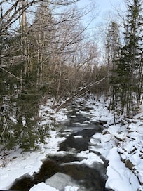 Back of the house sits above a beautiful brook - magical with all the snow.