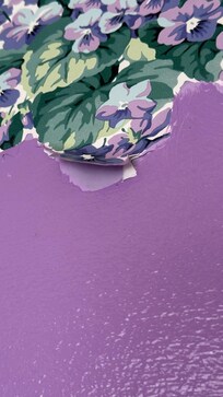 Peeling wallpaper and visible damage to the wall