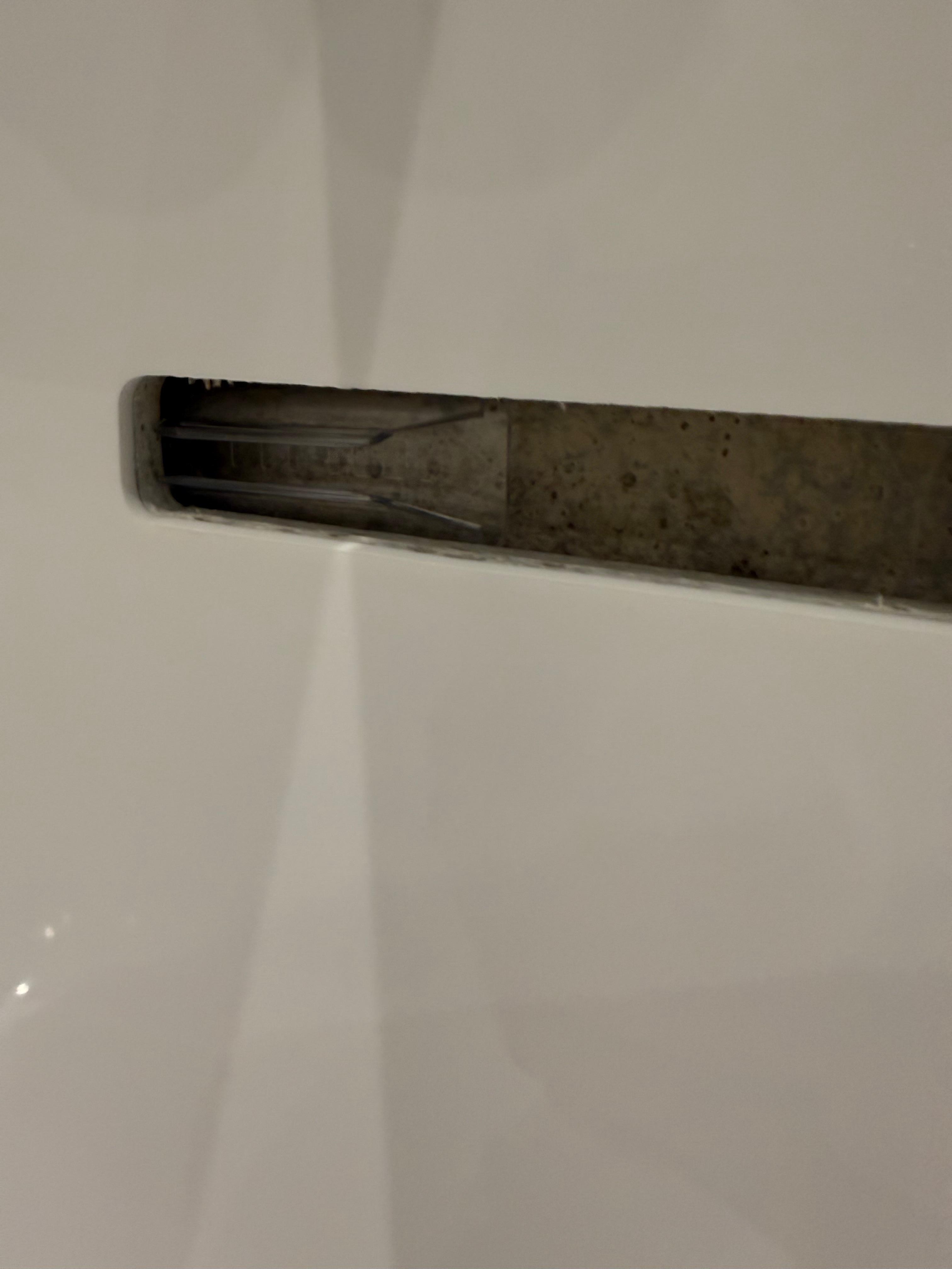 Plastic razor cover in bath overflow