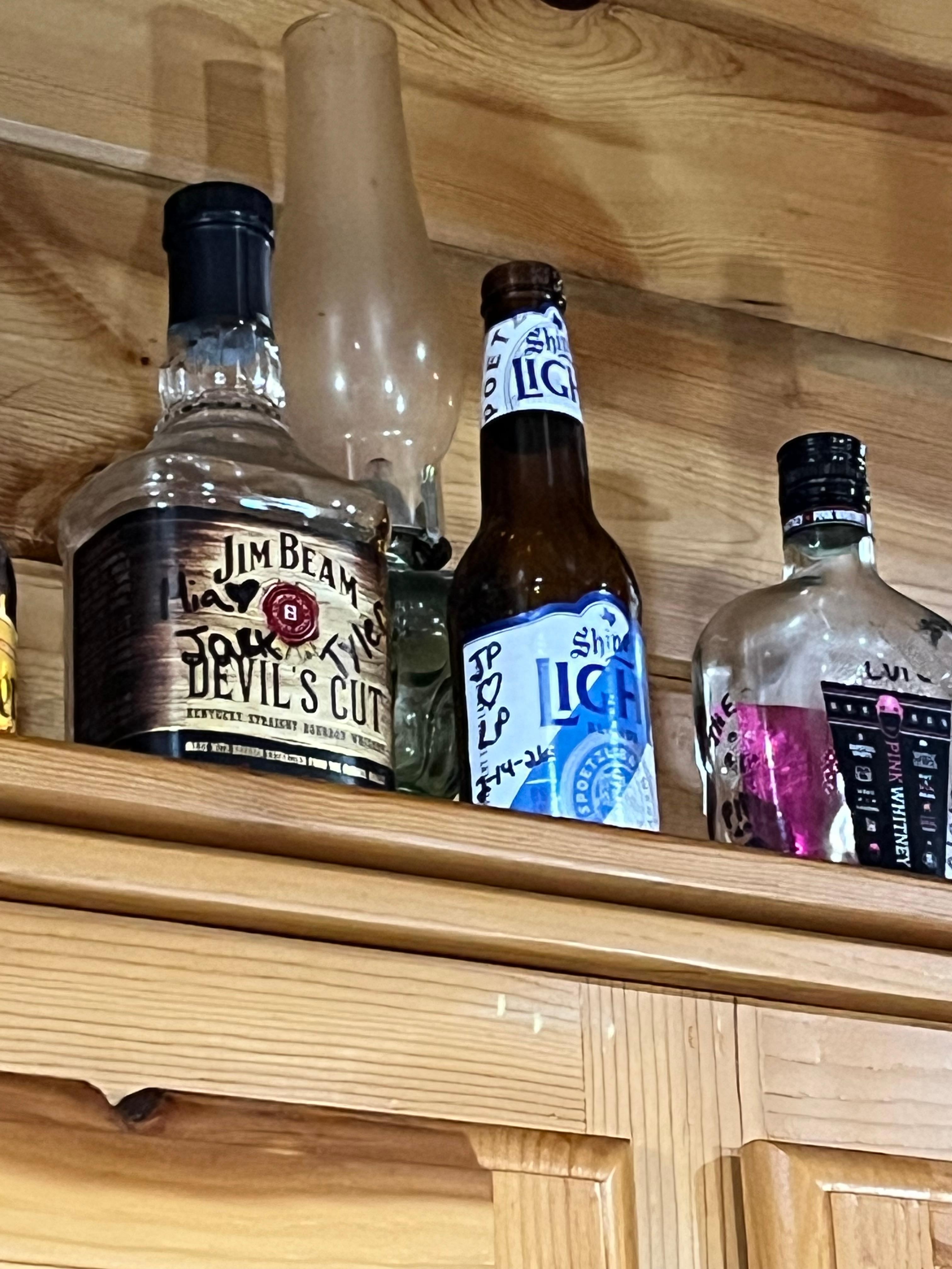 The kitchen has bottles people have left above the cabinets and some were signed. We added one as well. 