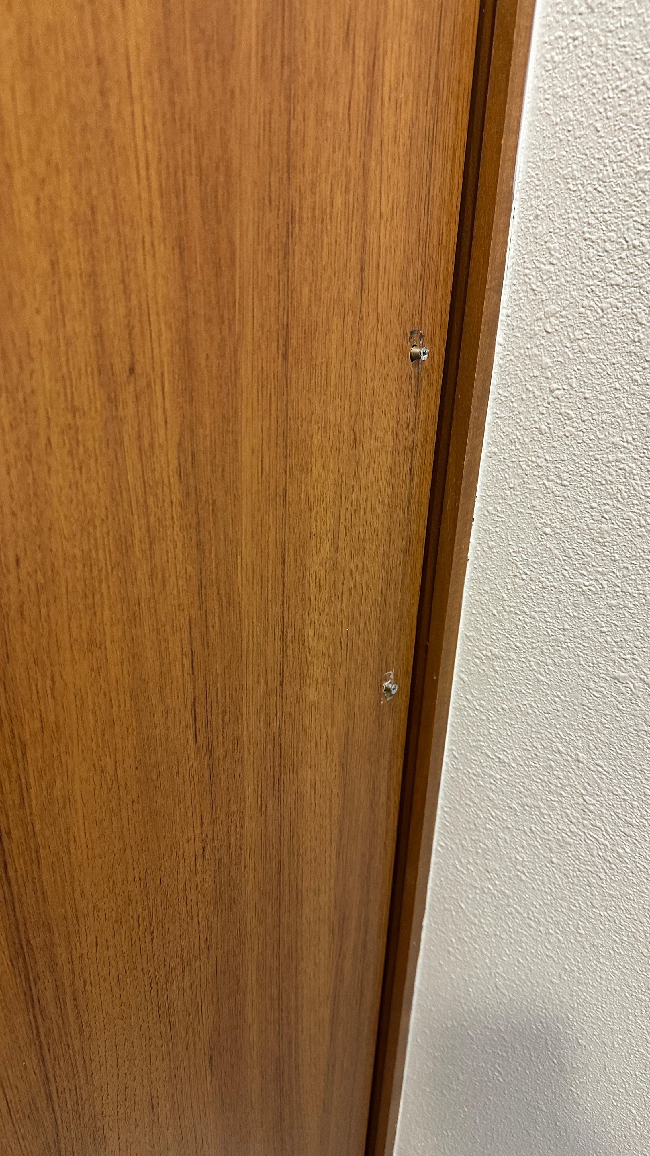 From inside the bathroom. Door handle screws sticking through the wood.