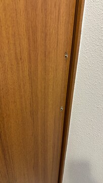 From inside the bathroom. Door handle screws sticking through the wood.