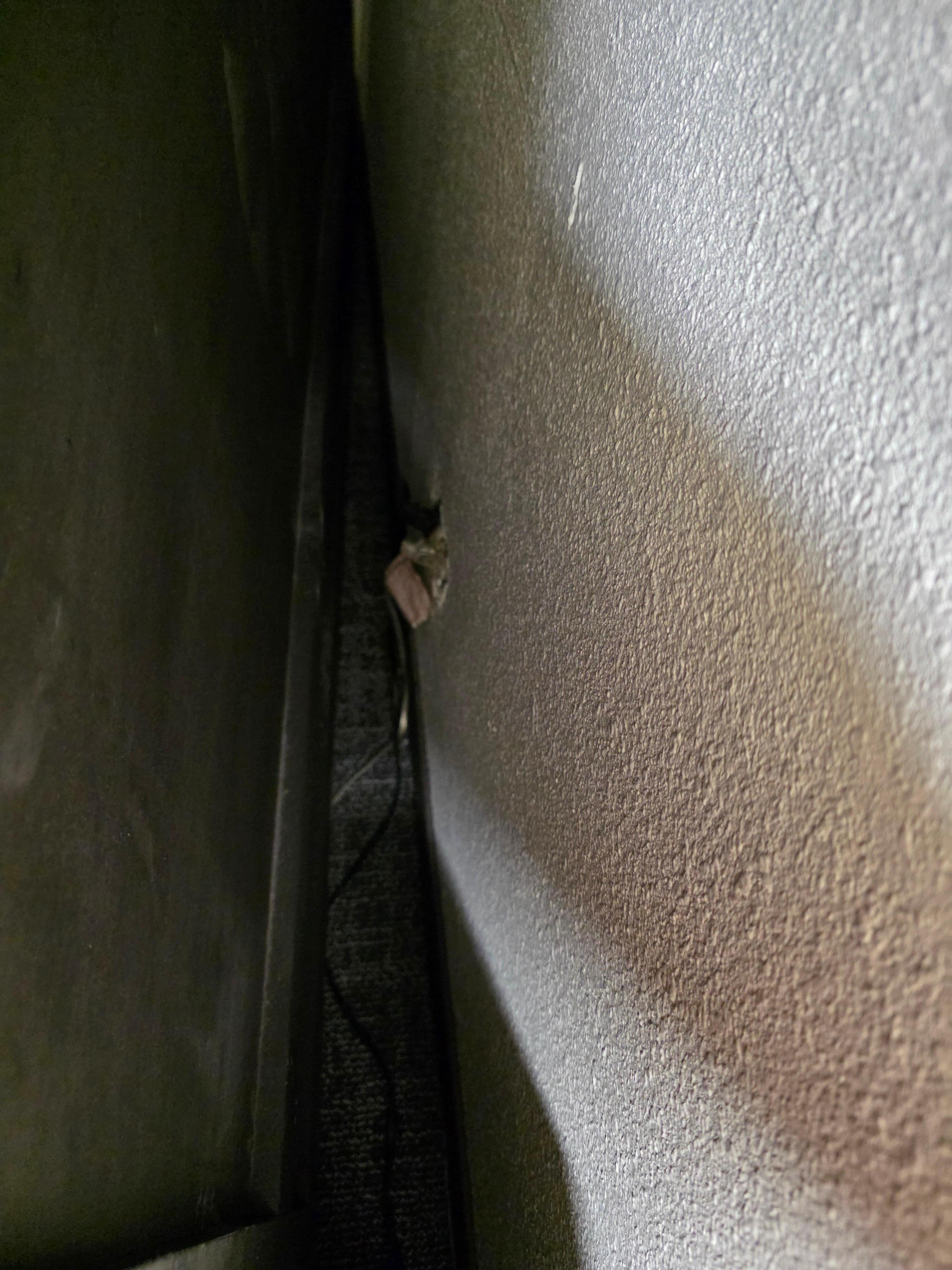 Outlet behind bed with no cover on it