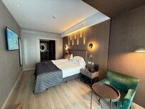 Comfortable King sized bed with a small sitting area and desk as well.