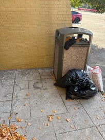 Garbage can outside entrance of hotel.