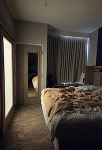 Bathroom light through door panel and bed in front of door.