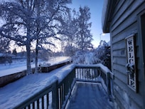 The snowy view out the front door, as the sun is peeking through.