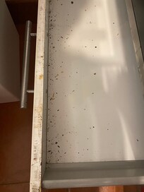 Filthy bottom drawer of range.