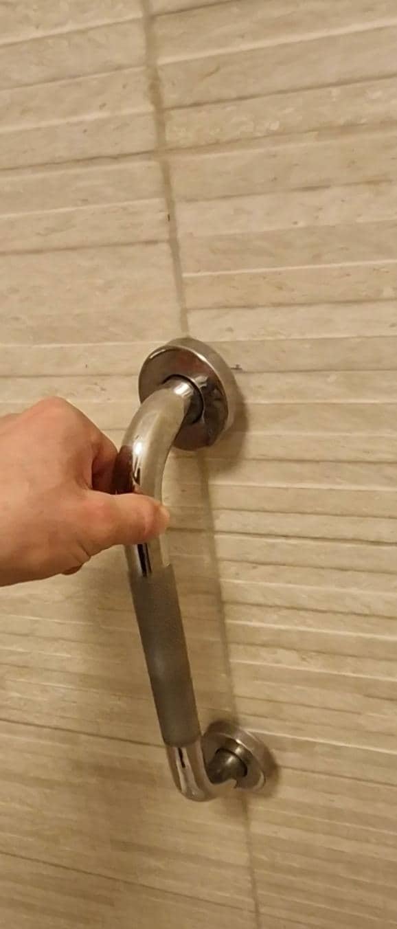 Poignée de douche cassée, non fixée au mur 