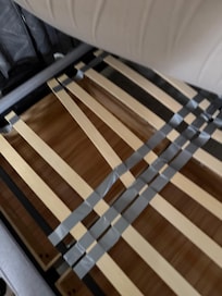 Broken bed slats under mattress in garage apartment.