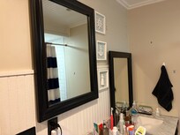 One mirror hung, the other, resting on the sink.