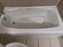 The tub/shower with peeling paint.