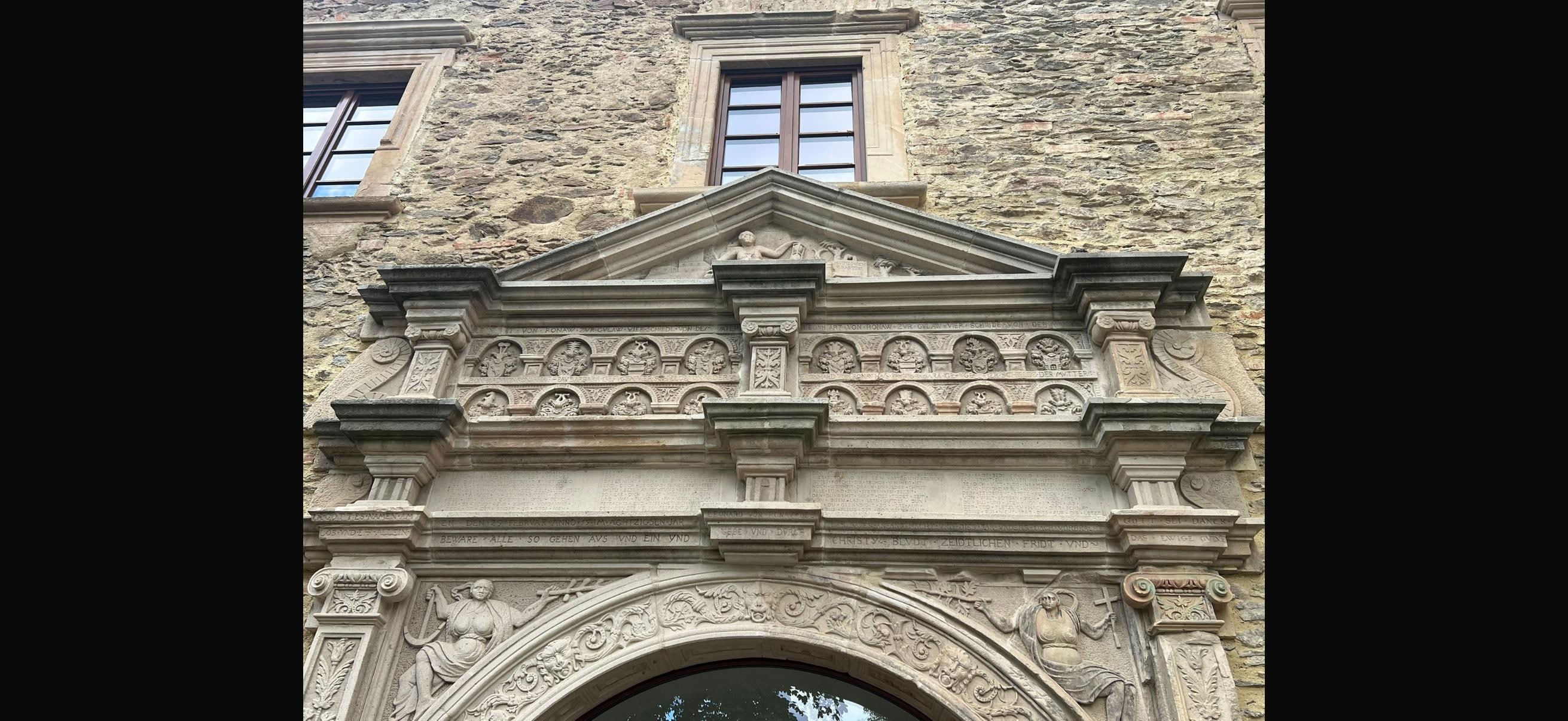 „BEWARE ALLE SO GEHEN AVS VND EIN
VND GEBT ACHT AVF EVERE SEELE VND
GEDENKT AN CHRISTVS BLEIBT
ZEITLICHEN FRIDT VND DAS EWIGE LEBEN” napis nad wejściem: „Strzeżcie się wszyscy, którzy wychodzicie i wchodzicie,
i zważajcie na wasze dusze,
i pamiętajci