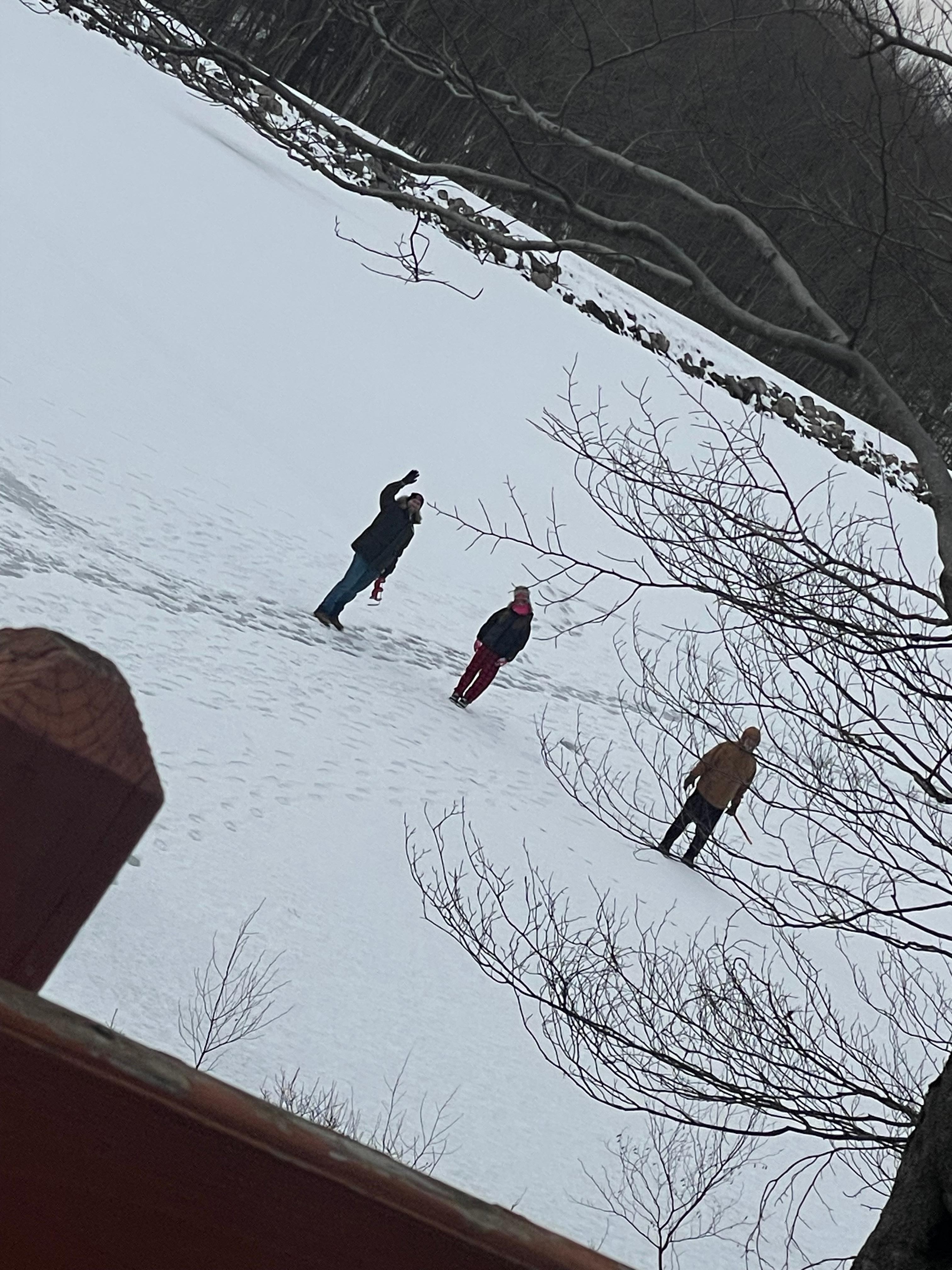 The pond froze over and the guys went out on the ice and did some ice fishing. 