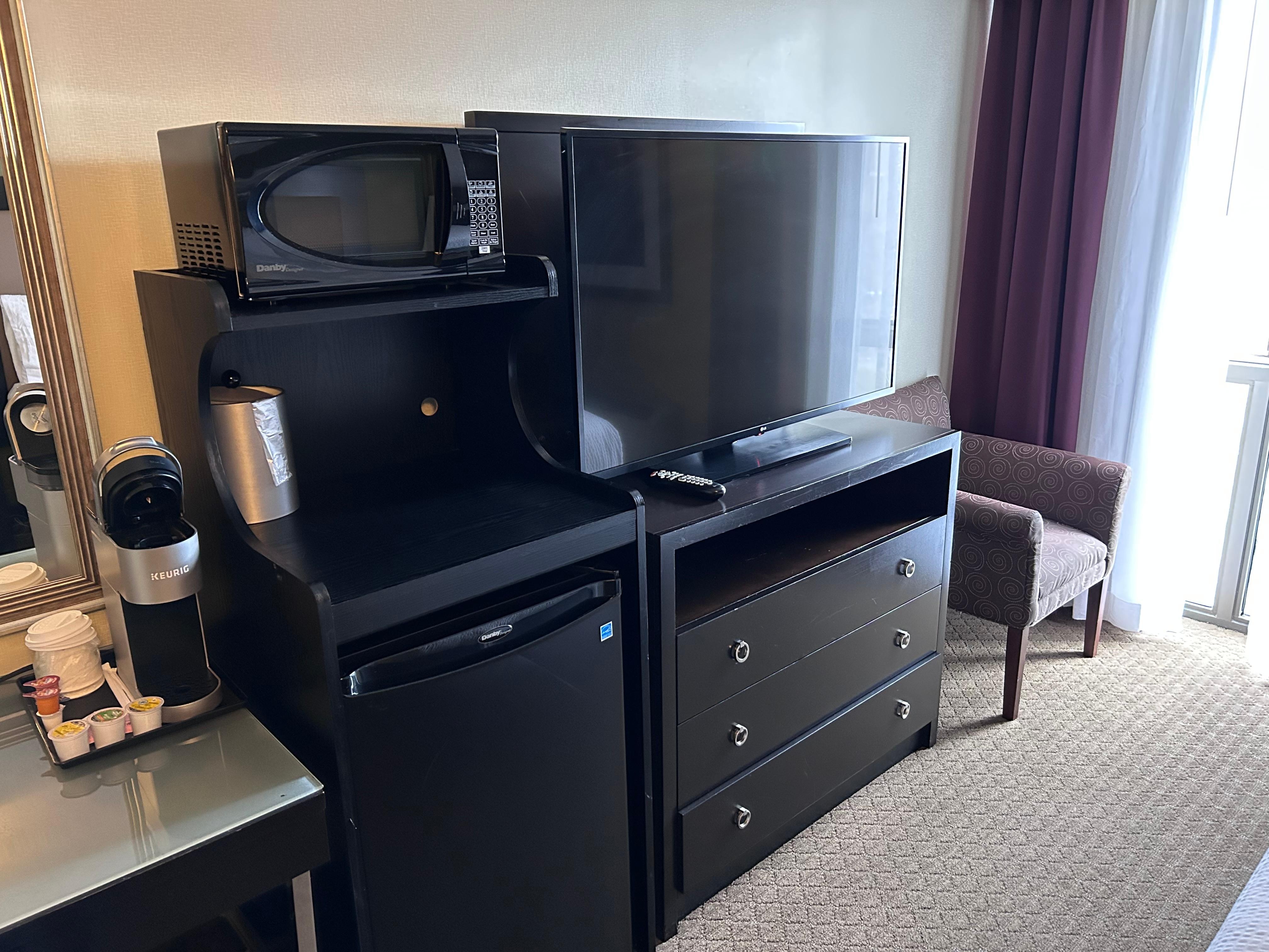 TV with multiple cable channels, microwave, and refrigerator