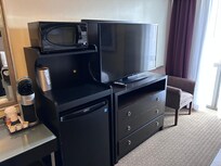 TV with multiple cable channels, microwave, and refrigerator