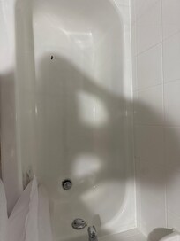 Rusty drain and gouge in the tub floor