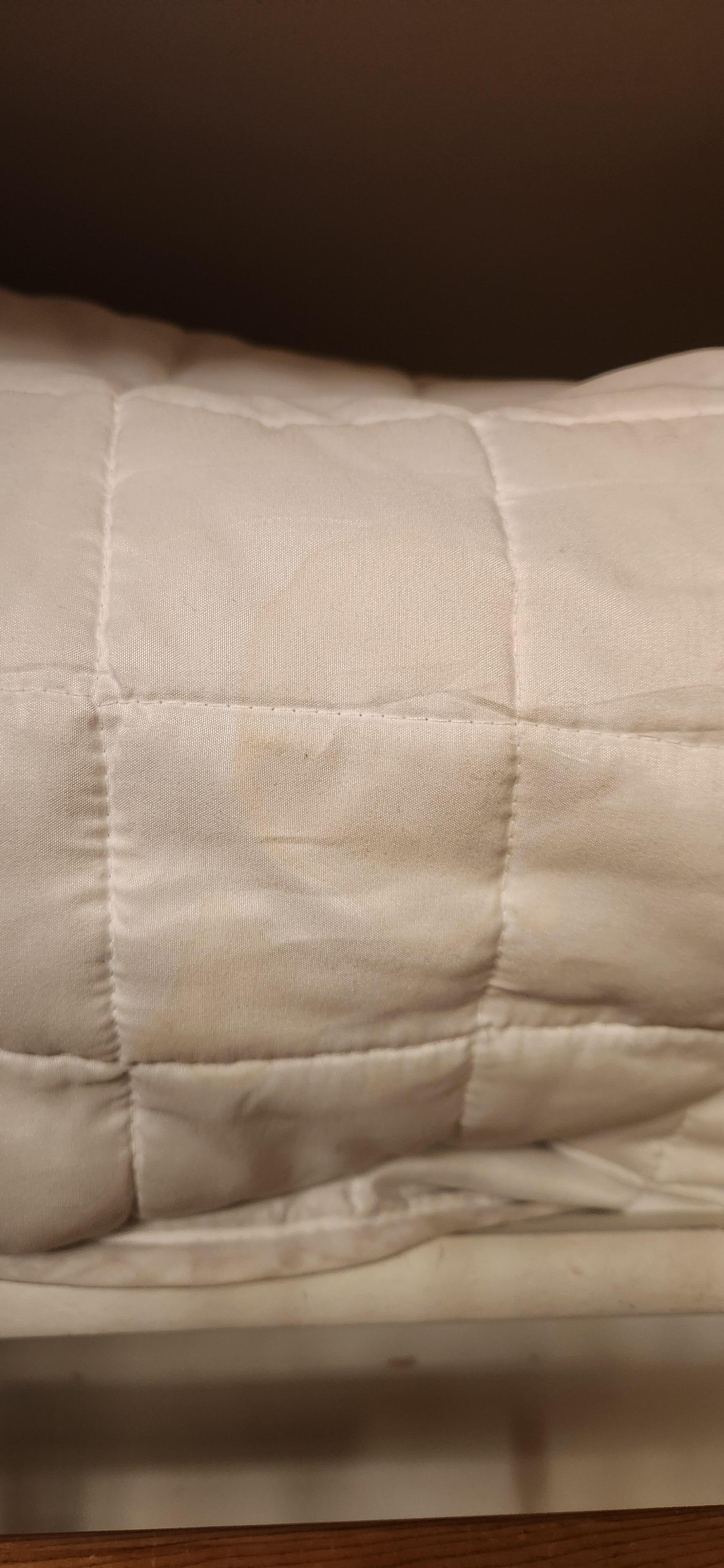 Big yellow stain on extra comforter in closet.