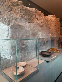 Living room area with ancient stone wall. Historical info and artifacts. Very cool!