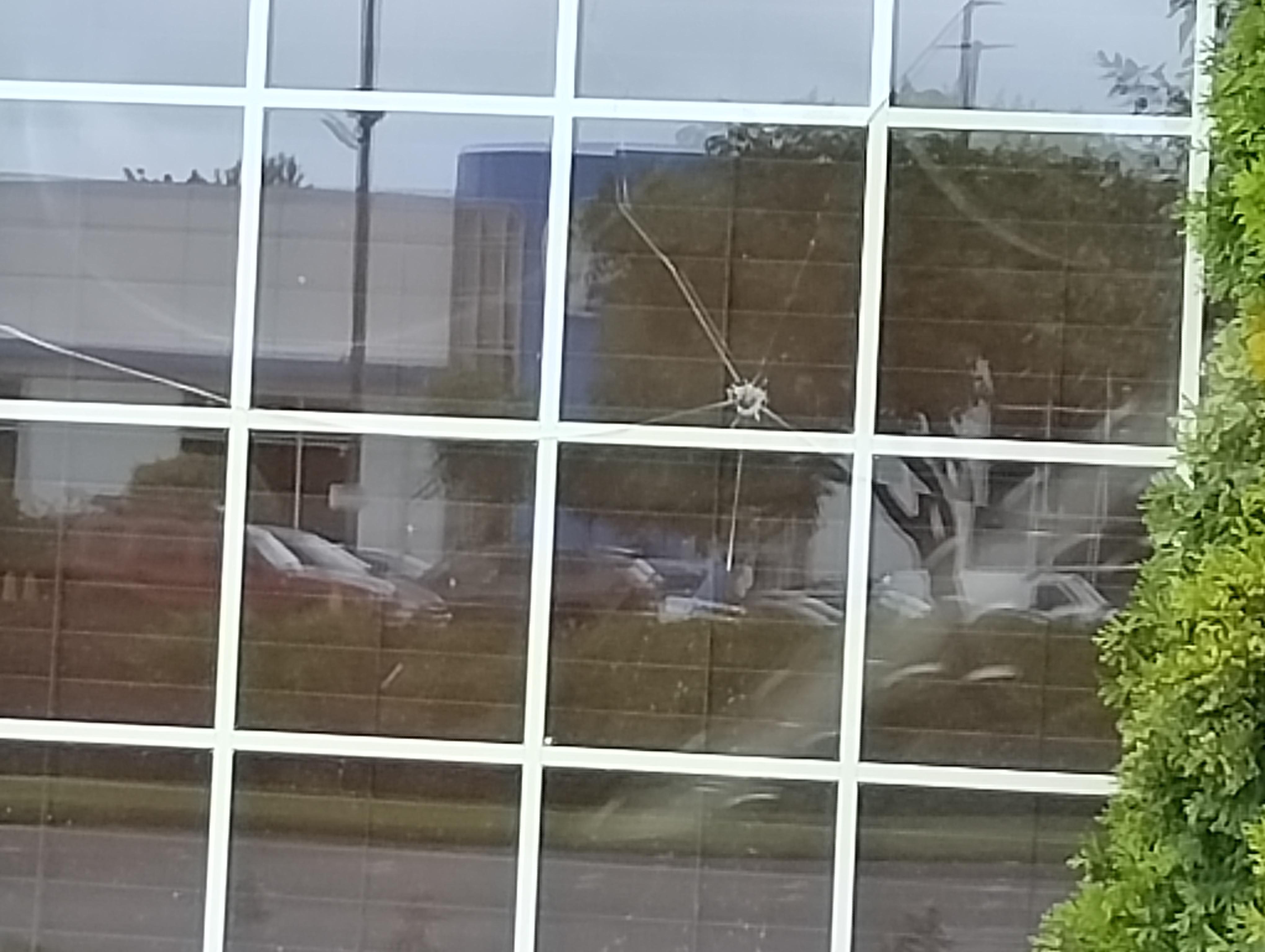 Bullet hole in lobby window causing the whole window to be cracked.