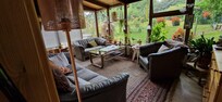 Schönes Wohnzimmer mit großem Fernseher, mit Blick in den schönen Garten