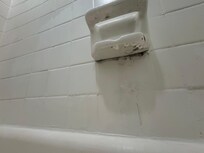 The underside of the soap holder in the bathtub