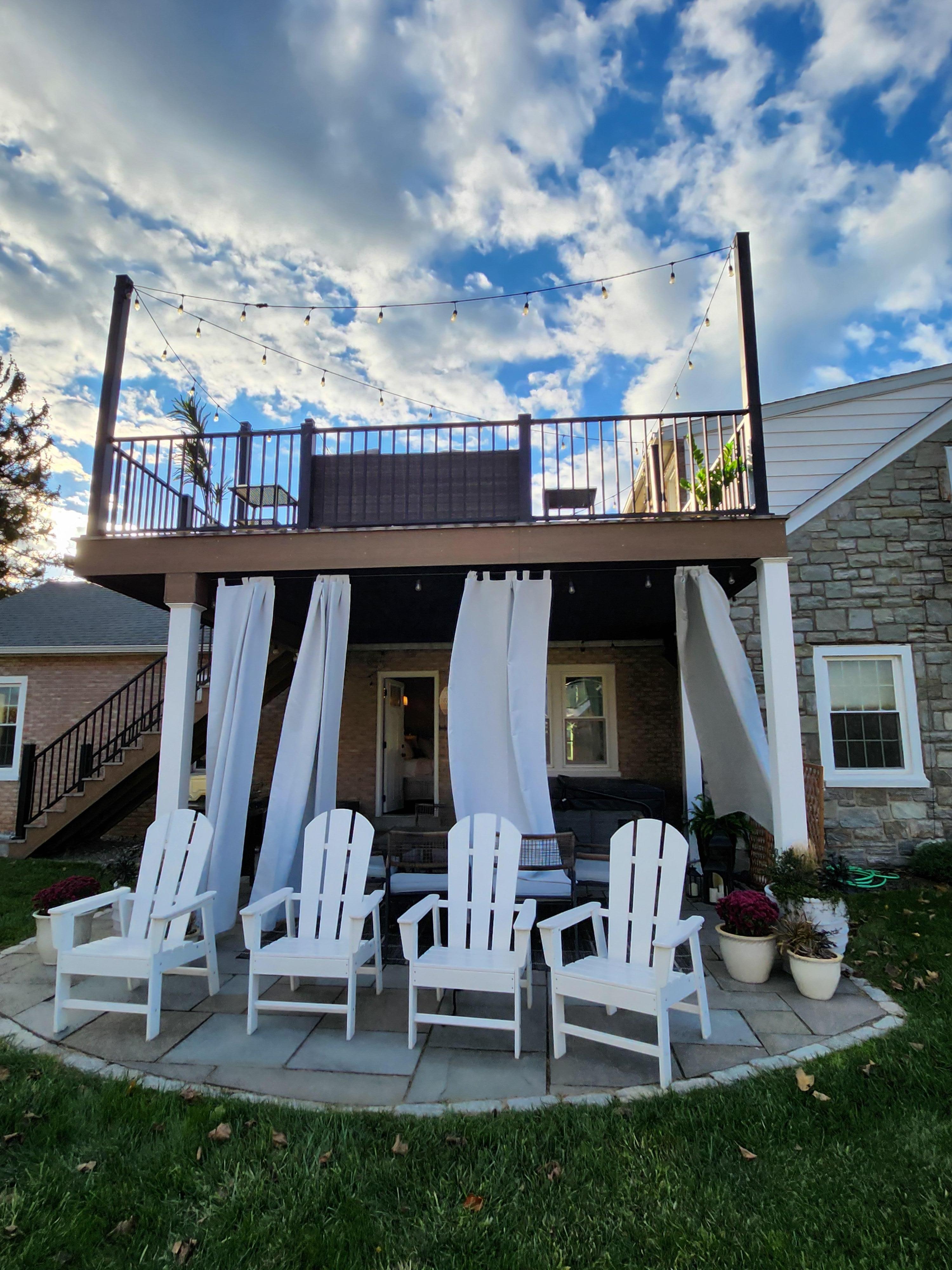Side of house with hot tub; grill; table and chairs