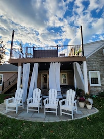Side of house with hot tub; grill; table and chairs